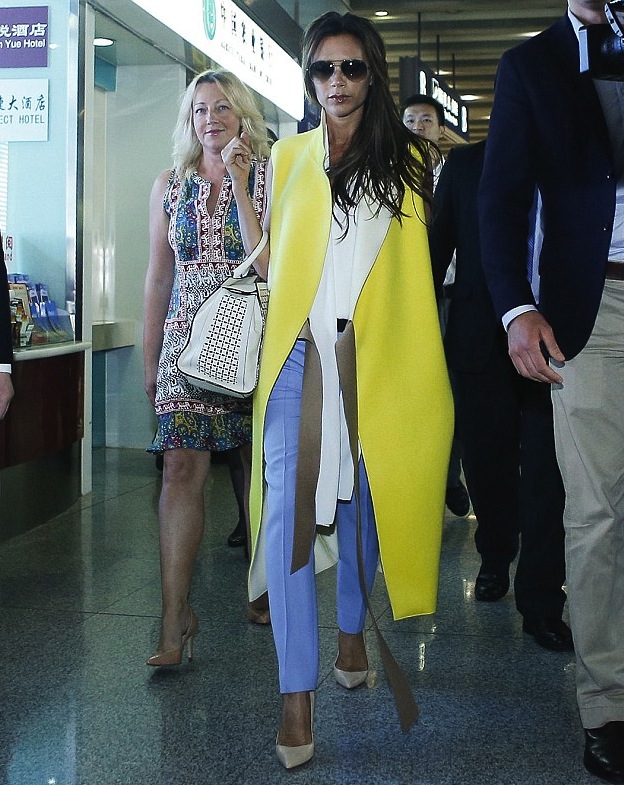 0-victoria-beckhams-beijing-aiport-victoria-beckham-fall-2013-yellow-sleeveless-coat-blue-pants-and-victoria-beckham-leather-tote.jpg